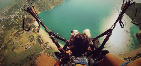 Person paragliding above a lake