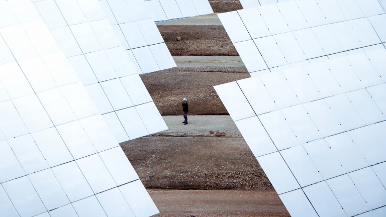 Man standing in a solar panels field