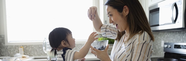 Mother cooking with daughter in kitchen