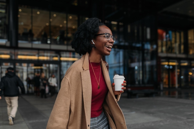 Young woman with coffee outside a building