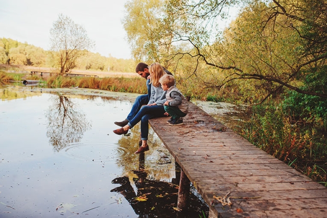 Family sitting on wall by the water