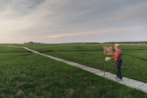 Senior man painting in a field