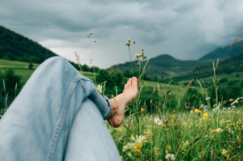Laying in the grass barefoot on a hillside